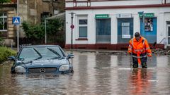 Mann watet über überflutete Straße