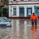 Mann watet über überflutete Straße