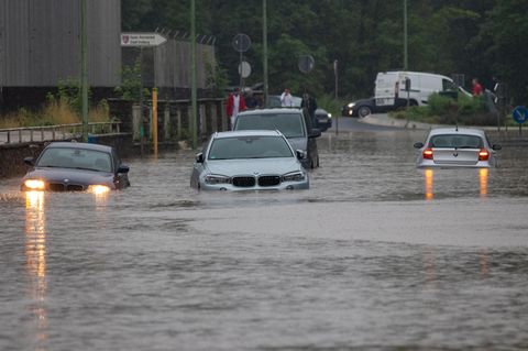 Nach Starkregen bahnen sich Autos ihren Weg über überflutete Straßen