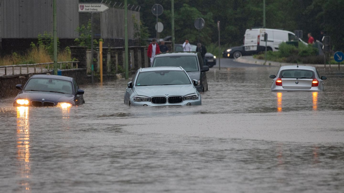 Nach Starkregen bahnen sich Autos ihren Weg über überflutete Straßen