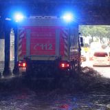 Feuerwehrwagen fährt unter einer überfluteten Bahnunterführung