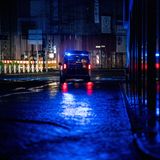 Ein Einsatzwagen der Polizei sichert eine überflutete Straße