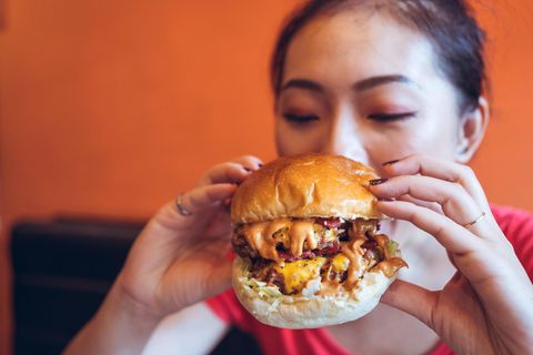 Eine Frau beißt in einen Burger