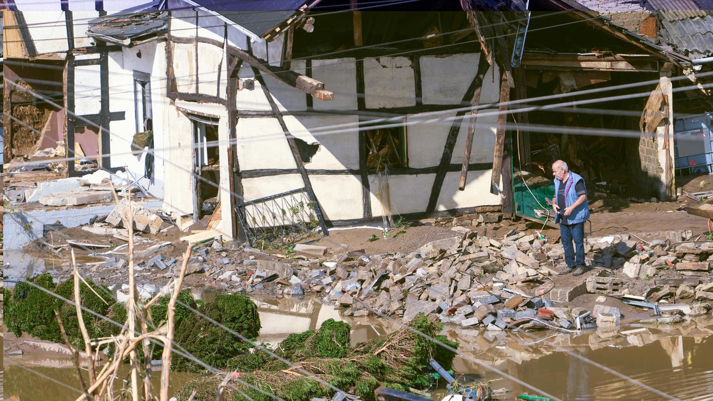Die ersten Bewohner kehren nach Schuld zurück und schauen, was das Hochwasser ihnen gelassen hat. Ein Mann steht neben einem zerstörten Fachwerkhaus im Schutt. Schwer zu sagen, ob das Haus noch zu retten ist