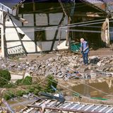 Die ersten Bewohner kehren nach Schuld zurück und schauen, was das Hochwasser ihnen gelassen hat. Ein Mann steht neben einem zerstörten Fachwerkhaus im Schutt. Schwer zu sagen, ob das Haus noch zu retten ist