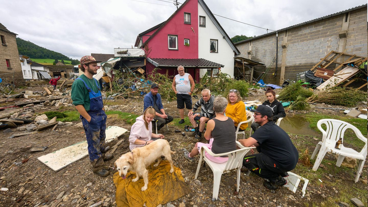 Anwohner sitzen am Tag nach dem Unwetter mit Hochwasser in Schuld zusammen – zumindest einer von ihnen kann noch oder wieder lächeln