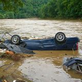 Eine dunkelblaue Limousine liegt auf dem Dach in der Ahr, nur die untere Hälfte schaut aus dem Wasser