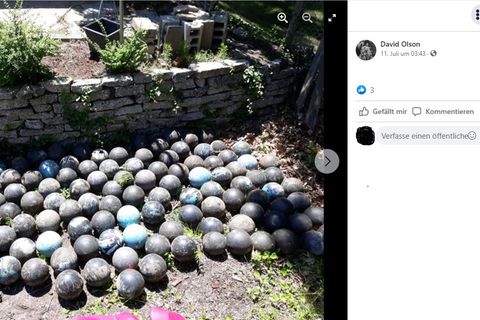 Sehr viele blaue Bowlingkugeln liegen in einer Wiese, der Screenshot ist von Facebook