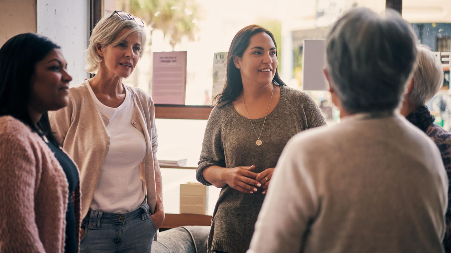 Frauen stehen im kreis und unterhalten sich angeregt