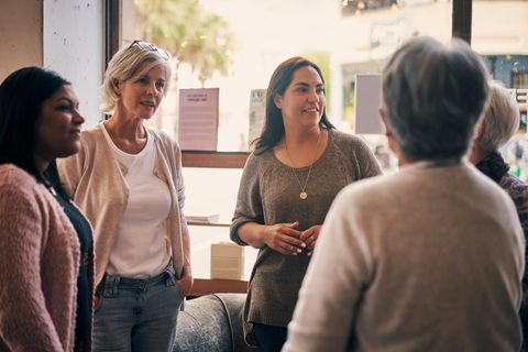 Frauen stehen im kreis und unterhalten sich angeregt