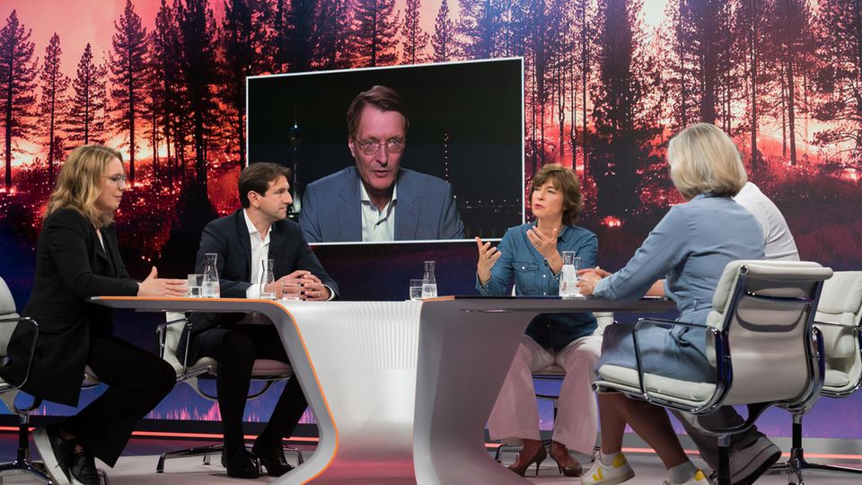 Gäste bei Maybrit Illner Menschen sitzen bei Maybrit Illner am Tisch und diskutieren, im Hintergrund ist ein Bildschirm für die Live-Schalte