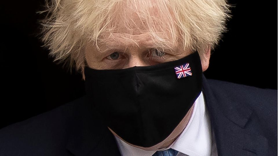 Boris Johnson trägt eine schwarze Maske mit der britischen Flagge