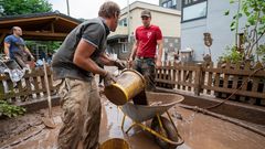 Das große Aufräumen in Kordel: Mit Eimern und Schubkarre entsorgen Anwohner die Schlammmassen nach dem Hochwasser der Kyll in Rheinland-Pfalz