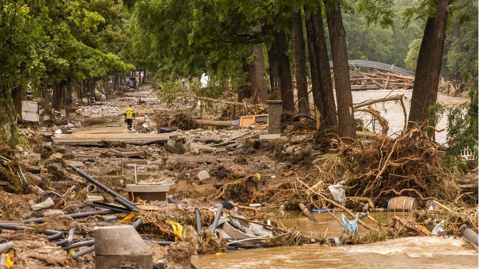Trümmerfeld durch Hochwasser: Ein Feuerwehrmann geht durch die Reste einer Straße in Bad Neuenahr in Rheinland-Pfalz.