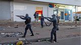 Hier stehen Soldaten in Johannesburg mit Schrotflinten im Anschlag auf der Straße, um mit Plünderungen fertig zu werden.