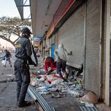 Im Angesicht der Ordnungskräfte: Plünderer kommen aus einem Geschäft