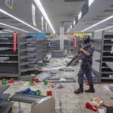 Supermarkt mit leeren Regalen: Ein Polizist geht durch ein geplündertes Geschäft in Johannesburg.