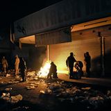 Soldaten wärmen sich im südafrikanischen Winter während ihres Einsatz zur Bekämpfung der Plünderungen und Unruhen an einem Feuer.