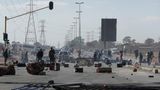 Während der anhaltenden Unruhen und Plünderungen in Südafrika: Demonstranten stehen hinter Barrikaden auf einer Straße in Soweto.