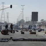 Während der anhaltenden Unruhen und Plünderungen in Südafrika: Demonstranten stehen hinter Barrikaden auf einer Straße in Soweto.