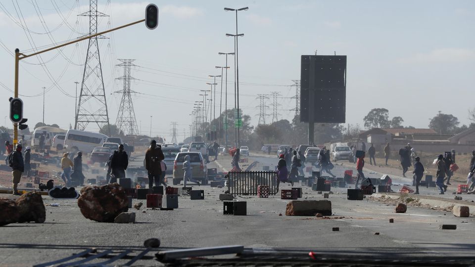 Während der anhaltenden Unruhen und Plünderungen in Südafrika: Demonstranten stehen hinter Barrikaden auf einer Straße in Soweto.