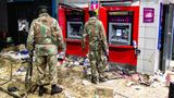 Nichts als Chaos: : Zwei bewaffnete Soldaten stehen nach den Ausschreitungen vor den Geldautomaten einer Bank.