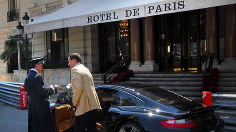 Ein Mann gibt sein Nobel-Auto dem Parkservice vor dem Hotel de Paris in Monaco