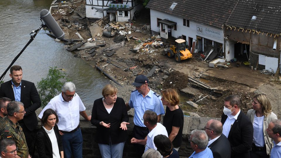 Merkel spricht mit Helfern und Betroffenen oberhalb des verwüsteten Dorfs