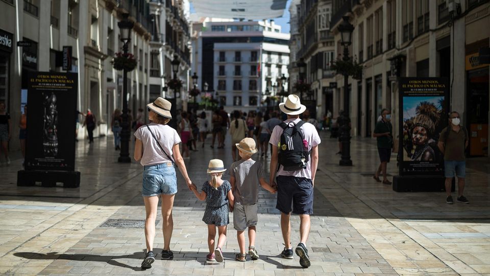 Eine Touristenfamilie spaziert durch Málaga: Die Corona-Krise im Urlaubsland Spanien hat sich weiter zugespitzt.
