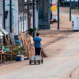 Solingen-Unterburg, Nordrhein-Westfalen: Ein Mann mit einem Handwagen geht an den Schuttbergen vorbei durch die Eschbachstraße