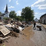 Iversheim, Nordrhein-Westfahlen: Menschen räumen Trümmer nach dem Hochwasser weg. Durch Iversheim im Kreis Euskirchen fließt die Erft, deren Pegel während der Unwetter massiv gestiegen ist. 