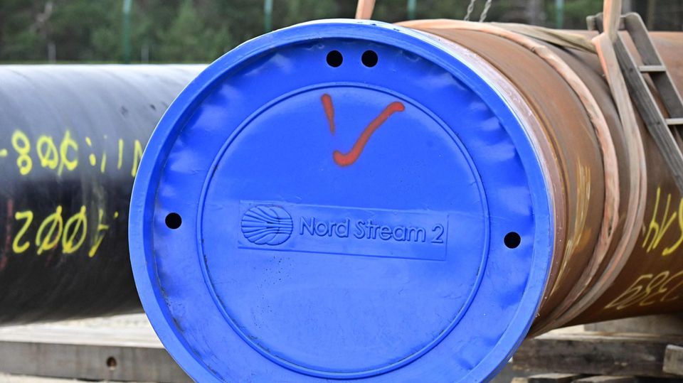 Ein riesiges Gasrohr ist mit einem blauen Deckel mit "Nord Stream 2"-Aufdruck verschlossen