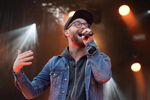 Mark Forster auf der Bühne mit Mikrofon in der Hand