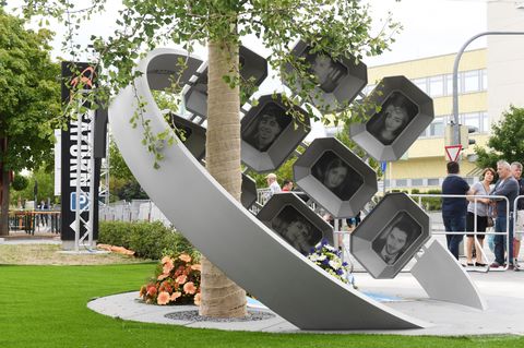 Das Mahnmal besteht aus einem Gingko-Baum, den ein zwei Meter hoher Edelstahlring, umfasst mit Fotos der Opfer