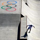 Ein Skateboarder fährt gerade von der linken Oberkante in eine Halfpipe mit großem "Tokyo 2020"-Schriftzug