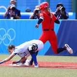Marta Gasparotto vom italienischen Softball-Team streckt sich vergeblich nach dem Ball, sodass Aubree Munro aus den USA recht entspannt die erste Base erreicht. Softball ist eine der Sportarten, in denen das Turnier schon vor Eröffnung der Spiele begonnen hat