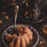 Halwa (Grießpudding mit Kardamom und Rosinen)      Zutaten: 200 g Zucker, 10 EL Pflanzenöl, 250 g Weichweizengrieß, 100 g Rosinen (oder ungesalzene Erdnüsse), 3 Kardamomkapseln, gehackte Nusskerne (z. B. Haselnusskerne) zum Bestreuen      Zubereitung:   1. Den Zucker mit 1 Tasse Wasser (ca. 200 ml) in einen kleinen Topf geben und unter Rühren erhitzen, bis der Zucker aufgelöst ist.  2. Das Öl in einer Pfanne erhitzen. Das Reismehl unter Rühren bei niedriger Temperatur einrieseln lassen und leicht braun anrösten. Dann das Zuckerwasser nach und nach unter die Reismehlschwitze rühren und alles etwa 5 Minuten köcheln lassen.  3. Die Rosinen und den Kardamom zugeben und den Brei weitere 10 Minuten köcheln lassen, dabei immer wieder umrühren. Wenn das Öl sichtbar wird, ist der Halwa fertig.  4. Zum Anrichten den Halwa in eine Schüssel umfüllen, mit gehackten Nüssen bestreuen und servieren.