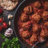 Kofta (Fleischbällchen in Tomatensauce)      Zutaten:   Für die Fleischbällchen: 2 Tomaten, 2 Zwiebeln, 4 Knoblauchzehen, ½ Bund frischer Koriander, 1 kg Rinder- und/oder Lammhackfleisch, Salz, frisch gemahlener schwarzer Pfeffer, 3 TL Korianderpulver   Für die Sauce: 3 Tomaten, 1 Zwiebel, 2 Knoblauchzehen, 3 EL Pflanzenöl, Salz, frisch gemahlener schwarzer Pfeffer, ½ TL Korianderpulver      Zubereitung:  1. Für die Fleischbällchen die Tomaten waschen und den Stielansatz herausschneiden. Die Zwiebeln und den Knoblauch abziehen. Die Tomaten sowie die Zwiebeln in feine Würfel schneiden und den Knoblauch fein hacken. Den Koriander waschen, trockenschütteln und ebenfalls fein hacken.  2. Das Hackfleisch mit den Zwiebeln und dem Knoblauch in einer Schüssel verkneten. Die Masse mit Salz, Pfeffer und dem Korianderpulver würzen. Dann die Tomaten und den frischen Koriander zufügen, alles gut vermengen und kurz ruhen lassen. Anschließend aus der Masse mit den Händen Bällchen formen.  3. Für die Sauce die Tomaten waschen und den Stielansatz herausschneiden. Die Zwiebel und den Knoblauch abziehen. Die Tomaten sowie die Zwiebel in feine Würfel schneiden und den Knoblauch fein hacken.  4. Das Öl in einem großen Topf erhitzen und die Zwiebel darin langsam goldbraun schmoren. Dann die Tomaten und den Knoblauch zufügen und die Mischung etwa 5 Minuten zu einer Sauce einköcheln lassen. Zuletzt mit Salz, Pfeffer und dem Korianderpulver würzen. Die Fleischbällchen in die Sauce geben und bei aufgesetztem Deckel etwa 25 Minuten darin garen.  5. Zum Anrichten die Kofta mit Sauce auf Teller verteilen und servieren. Dazu passt Brot.