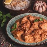 Qorme Morgh (Hähnchen-Curry)      Zutaten: 1 kg Hähnchenbrustfilet, 4 Tomaten, 2 Zwiebeln, 3 Knoblauchzehen, Pflanzenöl zum Anbraten, 1 TL Kreuzkümmelsamen, 1 TL Garam Masala, 1 TL Chilipulver, 4 EL Naturjoghurt, Salz, frisch gemahlener schwarzer Pfeffer, gehackter frischer Koriander zum Bestreuen (optional)      Zubereitung:   1. Die Hähnchenbrust trockentupfen und in etwa 3 cm große Stücke schneiden. Die Tomaten waschen und den Stielansatz herausschneiden. Die Zwiebeln und den Knoblauch abziehen. Die Tomaten sowie die Zwiebel in Würfel schneiden und den Knoblauch fein hacken.  2. Öl in einem Topf erhitzen und das Hähnchen darin anbraten. Dann die Zwiebeln dazugeben und braun anbraten. Die Tomaten, den Knoblauch und die Gewürze zufügen und die Mischung 10 Minuten weitergaren, bis eine sämige Sauce entstanden ist. Anschließend den Joghurt unterrühren und alles etwa 4 Minuten köcheln lassen, dabei immer wieder umrühren.  3. Zum Schluss mit Salz und Pfeffer abschmecken.  4. Zum Anrichten das Qorme Morgh auf Teller verteilen, nach Belieben mit frischem Koriander bestreuen und servieren. Dazu passt Brot.