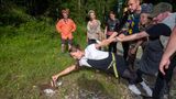  Alina versucht bei halb liegend eine Aufgabe zu erfüllen und wird dabei von den anderen Teilnehmern am Arm gehalten