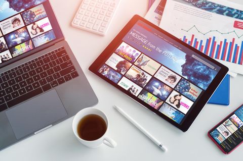 Tablet oder Laptop: Ein Tablet liegt rechts von einem Laptop auf dem Schreibtisch.