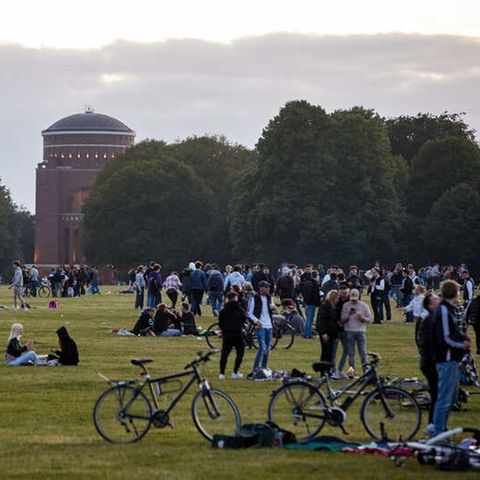 Jugendliche sitzen auf der Festwiese des Hamburger Stadtparks