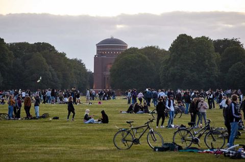 Jugendliche sitzen auf der Festwiese des Hamburger Stadtparks