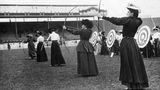 Olympiasiegerin Sybil "Queenie" Newall aus Großbritannien schießt sich bei den Olympischen Spielen 1908 in London zu Gold. In weniger als drei Jahren war Newall von einer obskuren Bogenschützin in einem Provinzverein zu einer Olympiasiegerin aufgestiegen. Interessanterweise wurden die Spiele 1908 ursprünglich in Rom geplant, wurden aber später in London ausgetragen, als sich herausstellte, dass Rom nicht bereit sein würde.