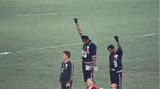 Die amerikanischen Sprinter Tommie Smith und John Carlos sowie der Australier Peter Norman kamen im 200-Meter-Lauf bei den Olympischen Spielen in Mexiko 1968 als die drei Ersten ins Ziel. Während der Siegerehrung protestierten Smith und Carlos gegen Rassendiskriminierung in ihrer Heimat, indem sie barfuß auf das Podium stiegen, sich während der Hymne verneigten und eine Faust mit einem schwarzen Handschuh erhoben.