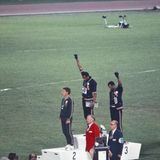 Die amerikanischen Sprinter Tommie Smith und John Carlos sowie der Australier Peter Norman kamen im 200-Meter-Lauf bei den Olympischen Spielen in Mexiko 1968 als die drei Ersten ins Ziel. Während der Siegerehrung protestierten Smith und Carlos gegen Rassendiskriminierung in ihrer Heimat, indem sie barfuß auf das Podium stiegen, sich während der Hymne verneigten und eine Faust mit einem schwarzen Handschuh erhoben.