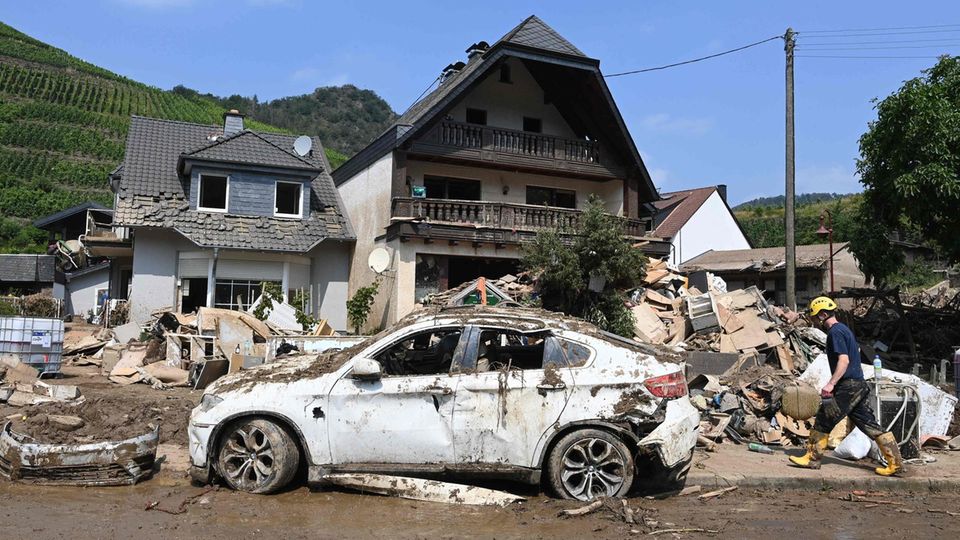 Ein halb zerstörtes Haus und ein verwüstetes Auto