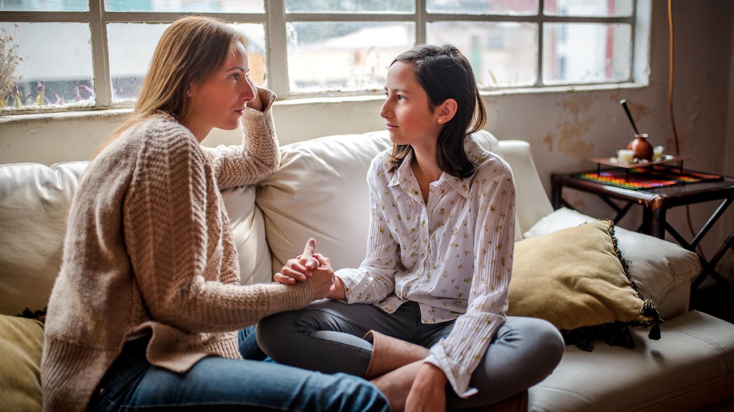Vergeben ist die wichtigste Eigenschaft, die du als Mutter brauchst Mutter und Tochter sitzen gemeinsam auf dem Sofa und führen ein ernstes Gespräch