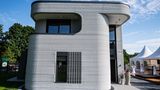 An der Außenfassade des ersten 3D Druckhauses sieht man die mittels eines 3D-Betondrucker aufgetragenen Betonschichten.
