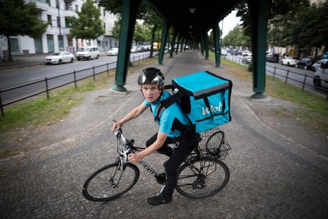 Ein Lieferant auf dem Fahrrad blickt in die Kamera